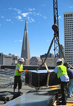 Occidental Power installers loading solar panels on roof in downtown San Francisco